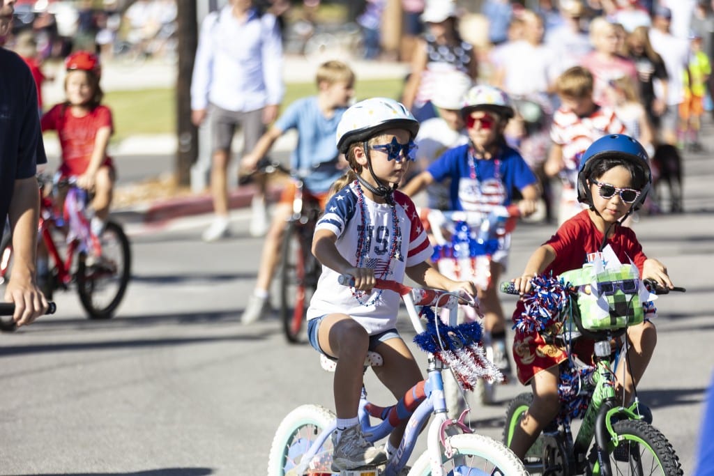 kids riding bikes decorated for Independence Day in a parade