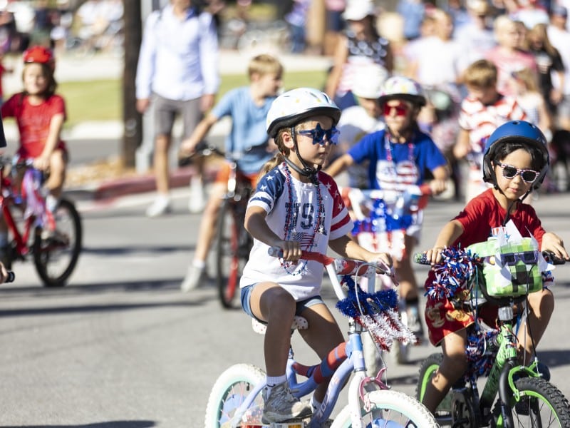 kids riding bikes decorated for Independence Day in a parade